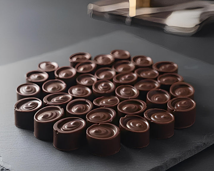 Round cannabis chocolate bonbons neatly arranged on a dark slate board in Cape Town, South Africa
