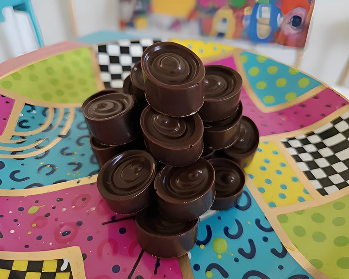 Stack of dark chocolate cannabis bonbons on a colorful plate in Cape Town, South Africa