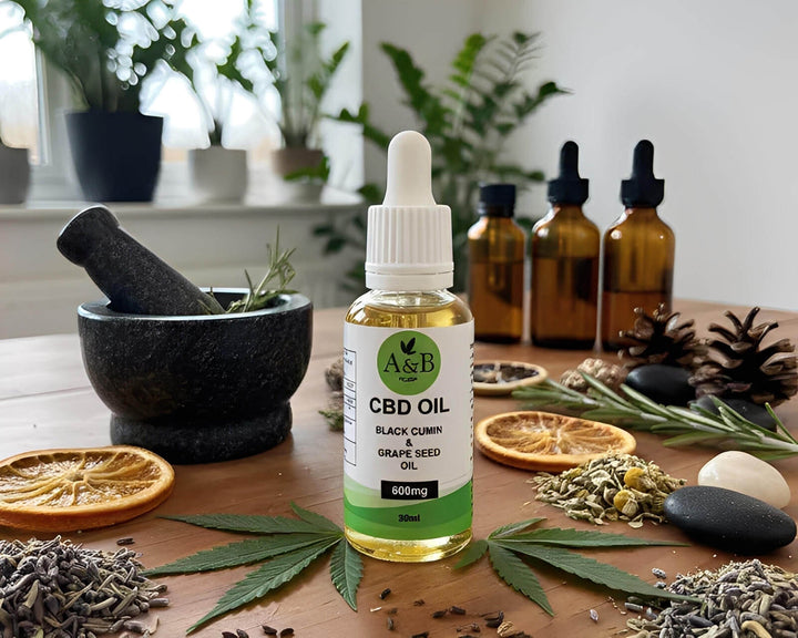 A&B CBD oil bottle with cannabis leaf, dried herbs, and amber bottles on a wooden table