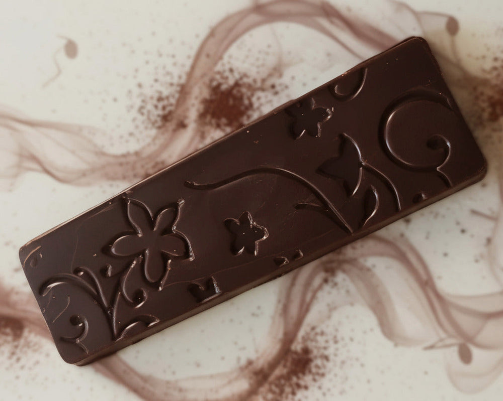 Dark chocolate slab with an elegant floral pattern displayed on a decorative plate in Cape Town, South Africa