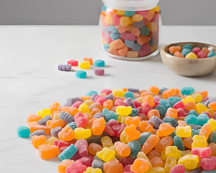 Assorted colorful cannabis gummies shaped like bugs on a marble surface in Cape Town