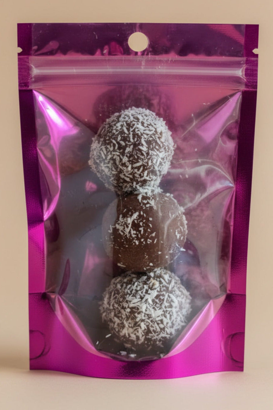 Purple mylar bag with 3 chocoalte dateballs on a wooden surface